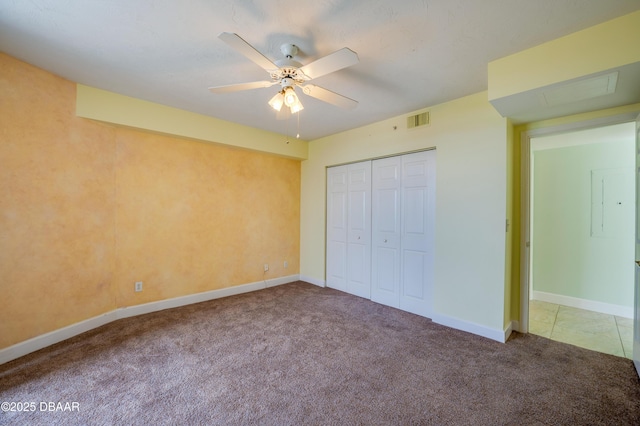 unfurnished bedroom featuring ceiling fan, a closet, and carpet flooring