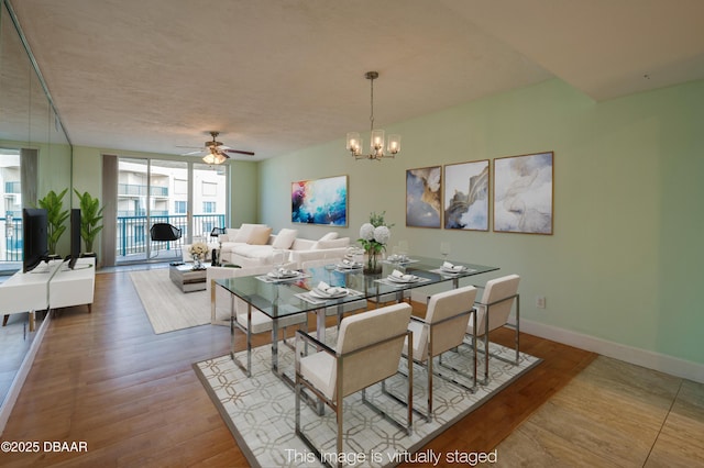 dining room featuring floor to ceiling windows, ceiling fan with notable chandelier, and hardwood / wood-style floors