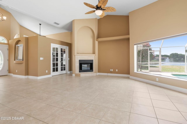 unfurnished living room with visible vents, baseboards, high vaulted ceiling, and a fireplace