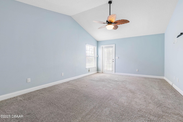 spare room with carpet flooring, baseboards, ceiling fan, and high vaulted ceiling