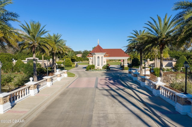 view of road featuring a gated entry and curbs