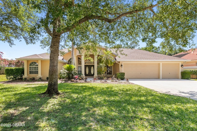 view of front of home with a garage, stucco siding, concrete driveway, and a front yard