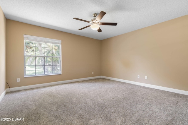 carpeted spare room with baseboards, a textured ceiling, and ceiling fan