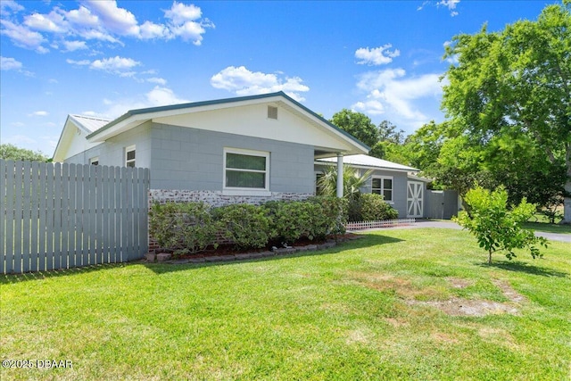 view of side of home with a yard and fence