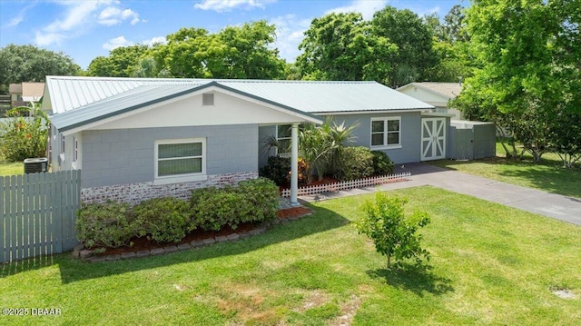 view of front facade with metal roof, fence, a front lawn, and central air condition unit