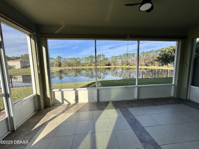 unfurnished sunroom featuring ceiling fan, a water view, and plenty of natural light