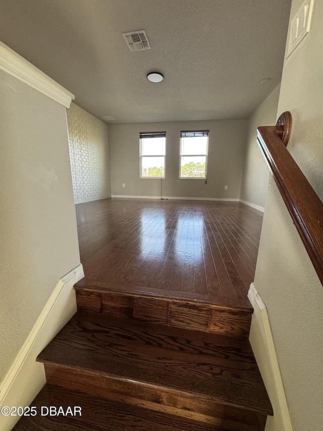 interior space featuring wood-type flooring and a textured ceiling