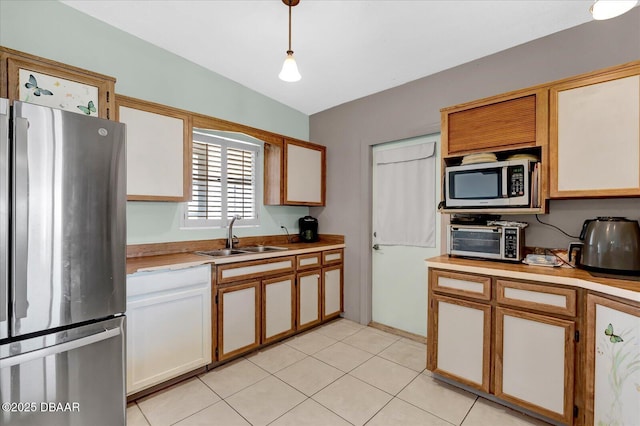 34 Dolphin Ave, Ormond Beach, FL 32176 - kitchen featuring appliances with stainless steel finishes, a sink, light countertops, decorative light fixtures, and light tile patterned floors
