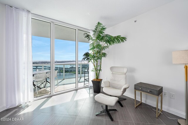 231 Riverside Dr Unit 1903-1, Daytona Beach, FL 32117 - sitting room with a wall of windows, a water view, and baseboards