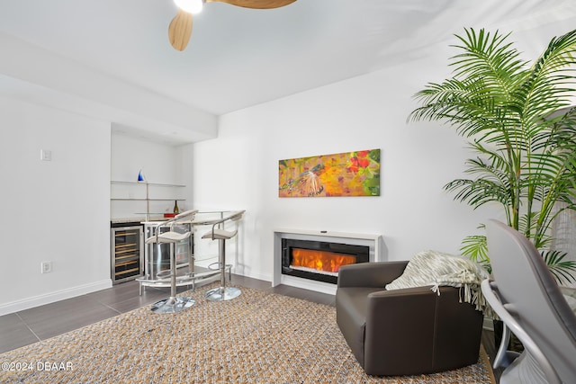 231 Riverside Dr Unit 1903-1, Daytona Beach, FL 32117 - sitting room with beverage cooler, a glass covered fireplace, a ceiling fan, a bar, and baseboards