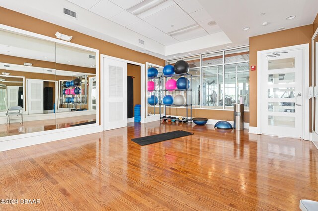 231 Riverside Dr Unit 1903-1, Daytona Beach, FL 32117 - workout room featuring wood finished floors, a tray ceiling, and baseboards