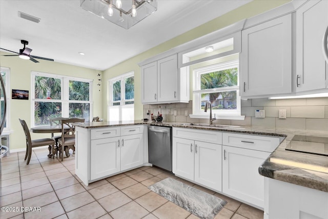 2 Bulows Lndg, Flagler Beach, FL 32136 - kitchen featuring stainless steel dishwasher, tasteful backsplash, a peninsula, white cabinets, and a sink