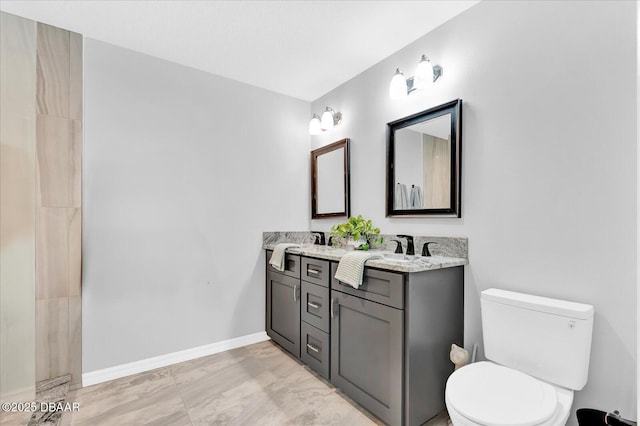 2 Bulows Lndg, Flagler Beach, FL 32136 - bathroom featuring toilet, double vanity, marble finish floors, and baseboards
