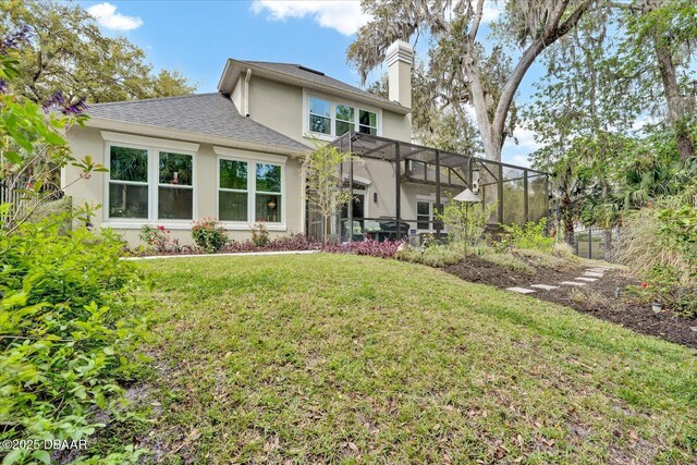 2 Bulows Lndg, Flagler Beach, FL 32136 - back of house with stucco siding, a yard, a chimney, a lanai, and a shingled roof