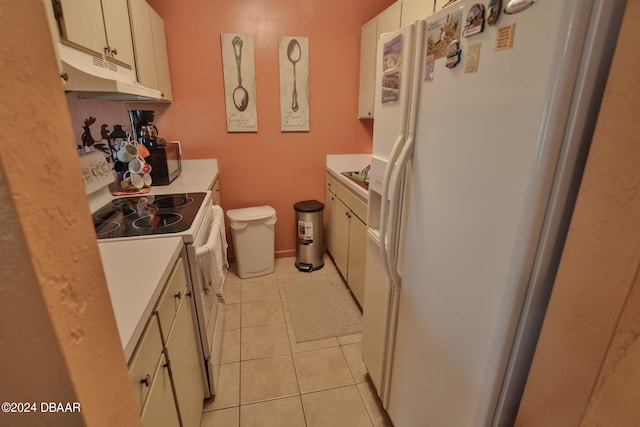 kitchen with white cabinetry, white appliances, and light tile patterned floors