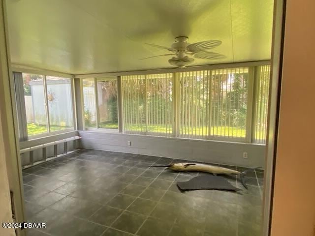 unfurnished sunroom featuring ceiling fan