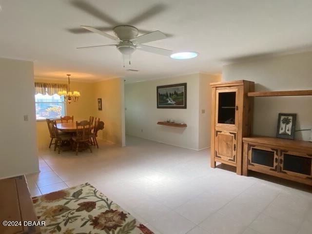 living room with ceiling fan with notable chandelier