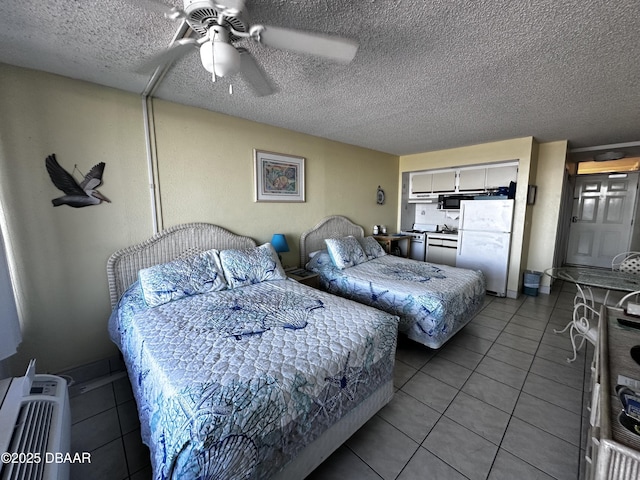 bedroom with ceiling fan, light tile patterned floors, white fridge, and a textured ceiling