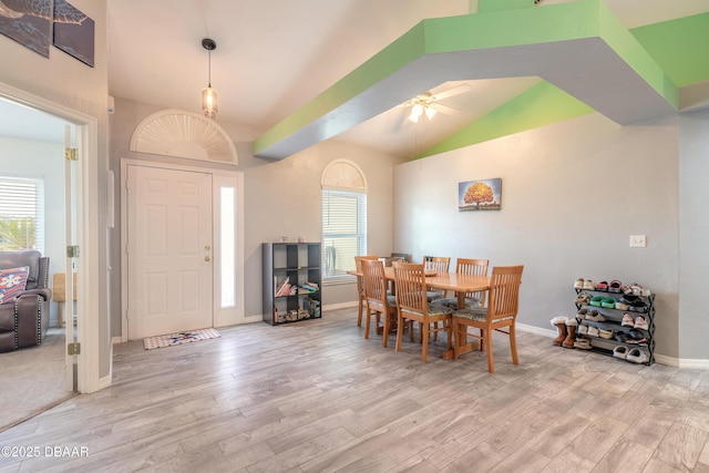 dining space with ceiling fan, light hardwood / wood-style floors, and vaulted ceiling