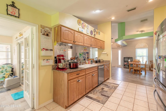 kitchen with light stone countertops, light tile patterned flooring, sink, and appliances with stainless steel finishes