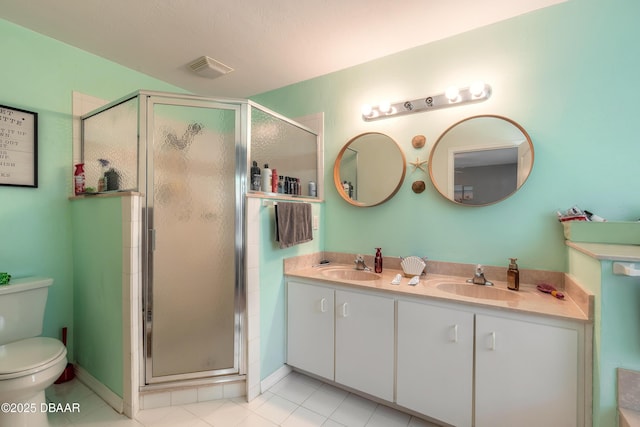 bathroom featuring toilet, a shower with door, vanity, and tile patterned floors