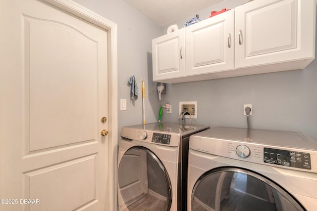 washroom featuring cabinets and washing machine and clothes dryer