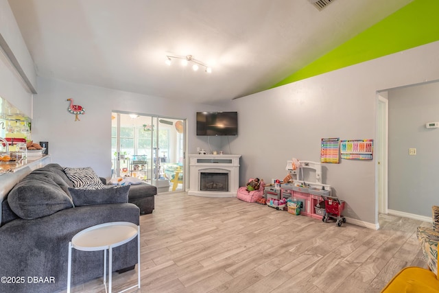 living room featuring light hardwood / wood-style floors and vaulted ceiling