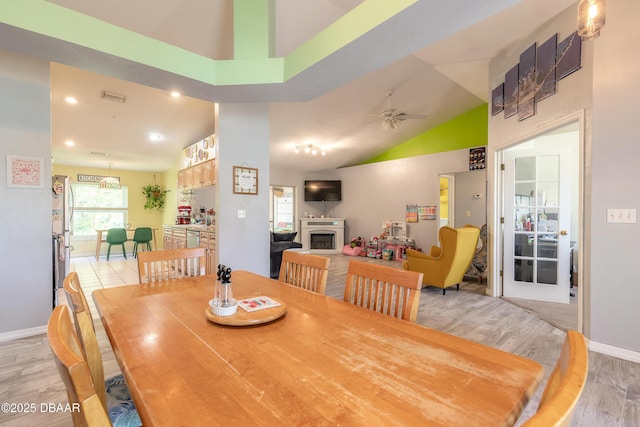 dining area with high vaulted ceiling, ceiling fan, and light hardwood / wood-style floors