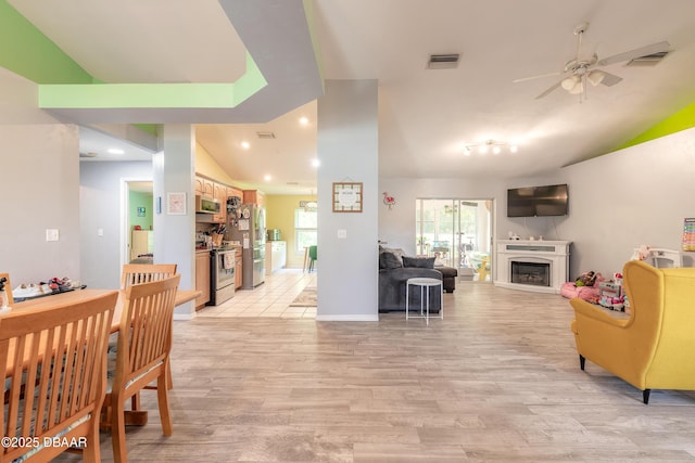 living room featuring ceiling fan, light hardwood / wood-style flooring, and lofted ceiling