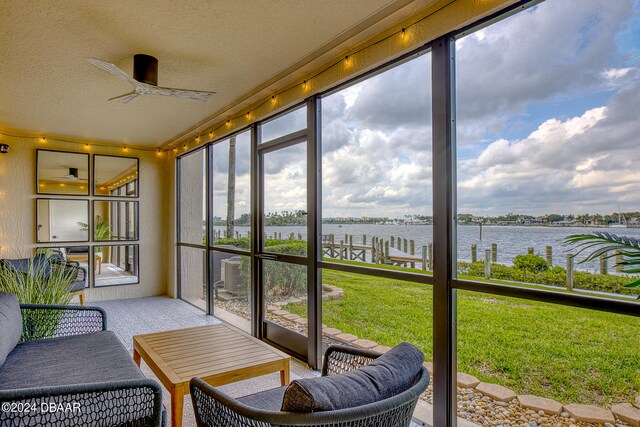 sunroom / solarium with a water view and ceiling fan