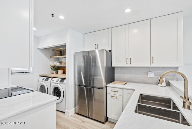 kitchen featuring sink, white cabinetry, independent washer and dryer, and stainless steel fridge