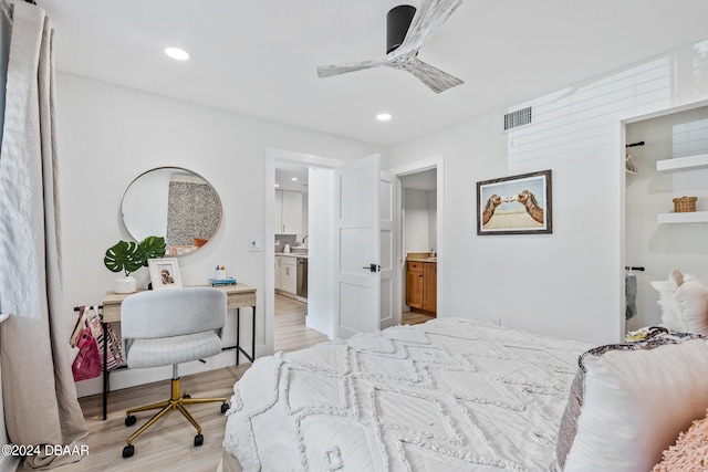 bedroom featuring connected bathroom, ceiling fan, and light hardwood / wood-style flooring