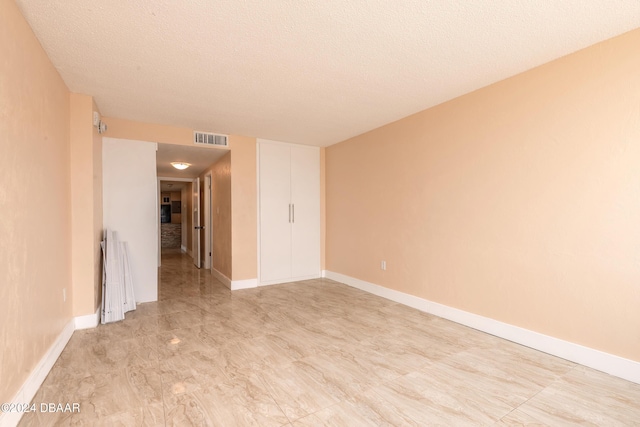 spare room with a textured ceiling