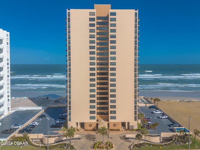 view of building exterior featuring a view of the beach and a water view