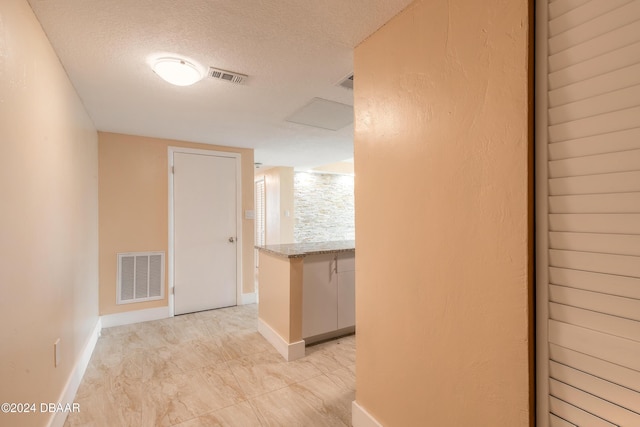 hall with a textured ceiling