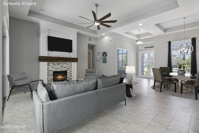 336 Stirling Bridge Dr, Ormond Beach, FL 32174 - living room featuring a tray ceiling, a lit fireplace, a ceiling fan, a chandelier, and recessed lighting