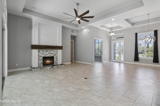 336 Stirling Bridge Dr, Ormond Beach, FL 32174 - unfurnished living room featuring a tray ceiling, ceiling fan, a stone fireplace, a chandelier, and recessed lighting