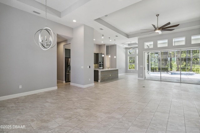 336 Stirling Bridge Dr, Ormond Beach, FL 32174 - unfurnished living room featuring a ceiling fan, a raised ceiling, a chandelier, a high ceiling, and recessed lighting