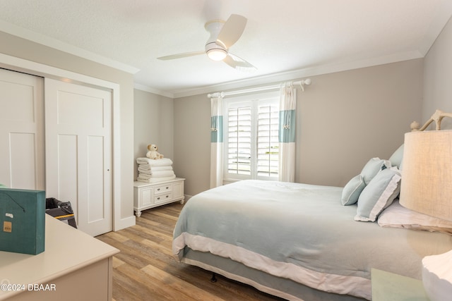 bedroom with ceiling fan, a closet, light hardwood / wood-style flooring, and ornamental molding