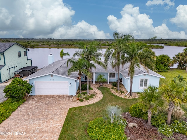 view of front of house with a garage, a water view, and a front yard