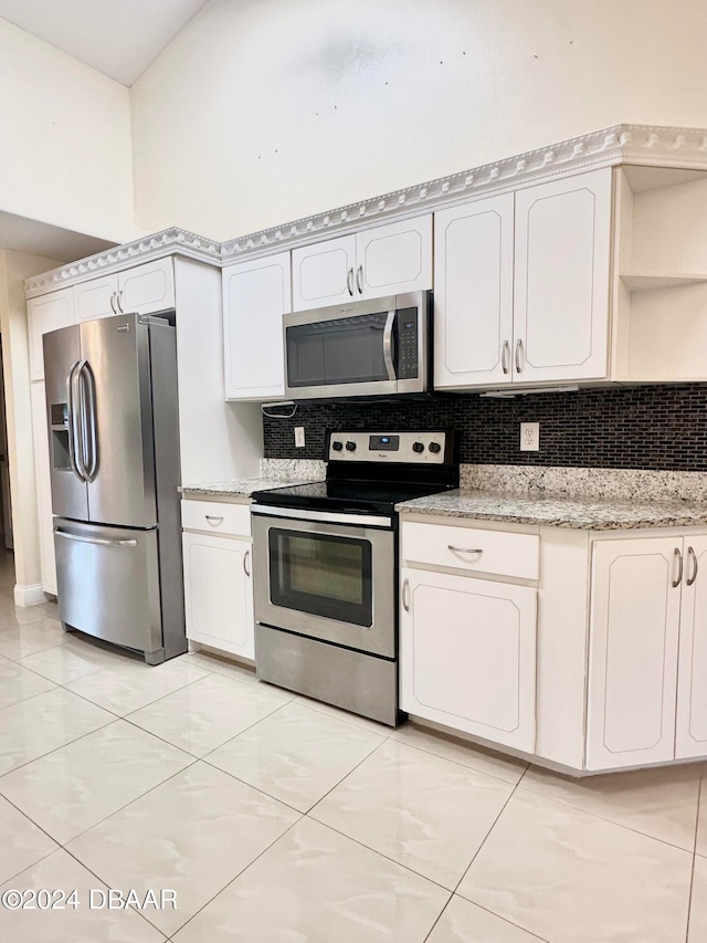 5 Wild Rose Pl, Palm Coast, FL 32164 - kitchen with stainless steel appliances, light stone countertops, white cabinets, and backsplash
