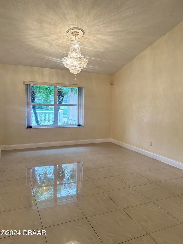 5 Wild Rose Pl, Palm Coast, FL 32164 - spare room featuring a textured ceiling and a notable chandelier