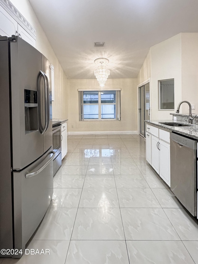 5 Wild Rose Pl, Palm Coast, FL 32164 - kitchen featuring stainless steel appliances, white cabinetry, sink, an inviting chandelier, and lofted ceiling