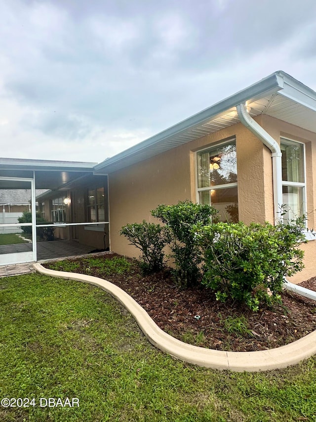 5 Wild Rose Pl, Palm Coast, FL 32164 - view of home's exterior with a lawn and a sunroom
