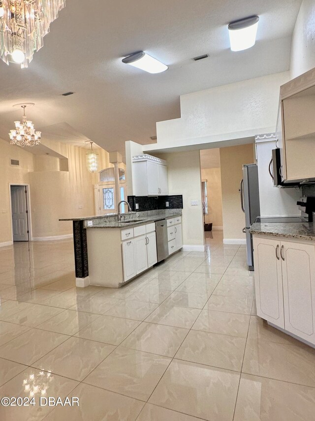 5 Wild Rose Pl, Palm Coast, FL 32164 - kitchen featuring stainless steel appliances, white cabinetry, sink, kitchen peninsula, and decorative light fixtures