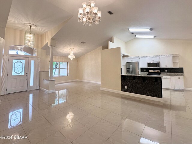 5 Wild Rose Pl, Palm Coast, FL 32164 - tiled entryway with high vaulted ceiling and a notable chandelier