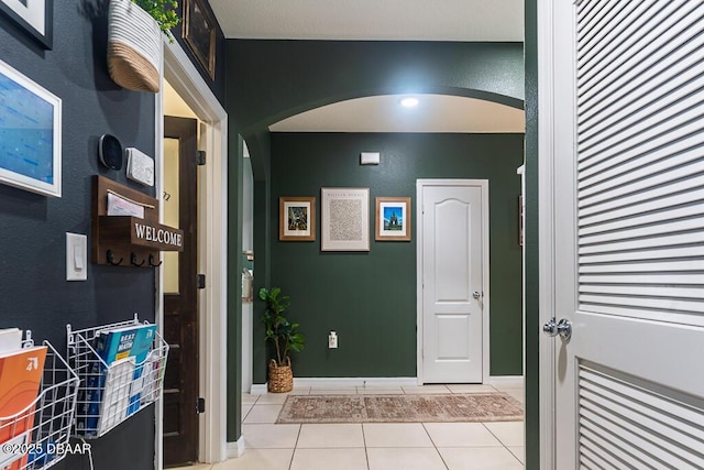 2756 Star Coral Ln, New Smyrna Beach, FL 32168 - hallway with arched walkways, light tile patterned flooring, and baseboards