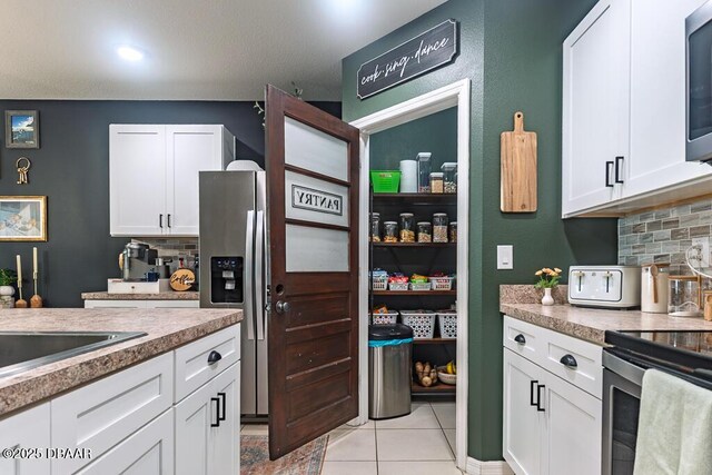 2756 Star Coral Ln, New Smyrna Beach, FL 32168 - kitchen with stainless steel appliances, tasteful backsplash, and white cabinetry