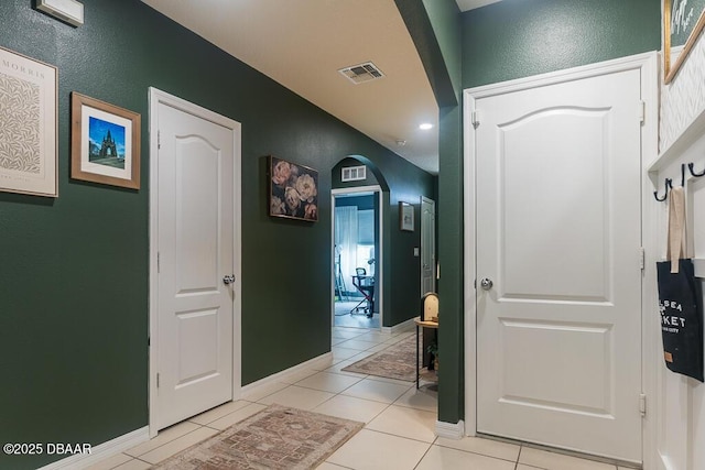 2756 Star Coral Ln, New Smyrna Beach, FL 32168 - hallway with arched walkways, light tile patterned flooring, a textured wall, baseboards, and recessed lighting