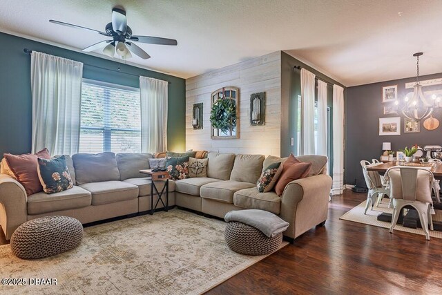 2756 Star Coral Ln, New Smyrna Beach, FL 32168 - living room featuring a chandelier, wood finished floors, a ceiling fan, an accent wall, and wooden walls
